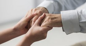 nurse-holding-senior-man-s-hands-for-sympathy