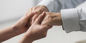 nurse-holding-senior-man-s-hands-for-sympathy